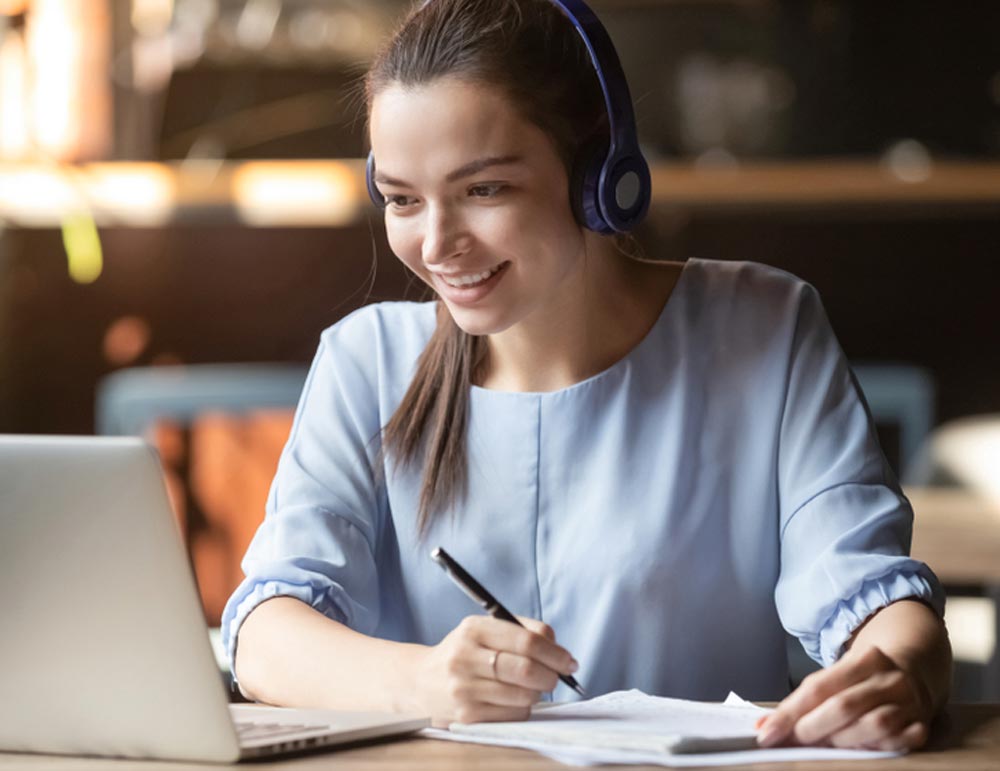 Smiling girl student wear wireless headphone study online with skype teacher