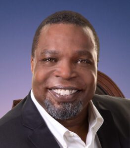Smiling man in suit against blue background.